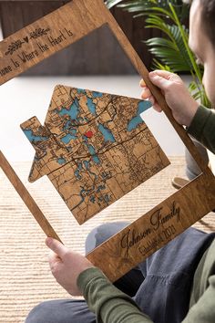 a person is holding up a wooden map