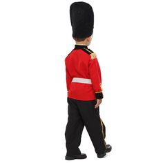 a little boy in a red uniform is walking