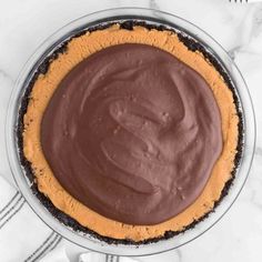 an overhead view of a chocolate pie on a marble table