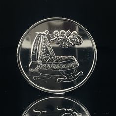 a silver coin with an image of a boat on it