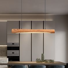 a wooden light fixture hanging over a kitchen table with blue chairs and stools in front of it