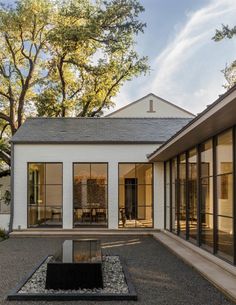 a white house with lots of windows and glass doors on the front side of it