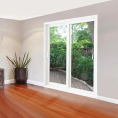 an empty living room with wood floors and sliding glass doors