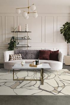 a living room with a couch, coffee table and potted plant in the corner