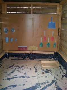 the inside of a wooden shed with tools on the wall and paint splattered floor