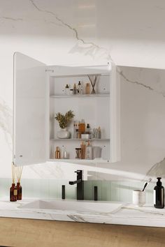 a bathroom sink with an open medicine cabinet above it