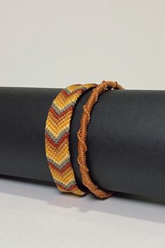 two bracelets sitting on top of a black piece of cloth next to each other