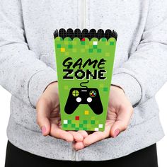 a person holding a video game case in their hands with the text game zone on it