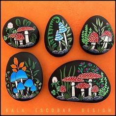 four painted rocks with mushrooms on them sitting on an orange surface and the words kala esobar designs