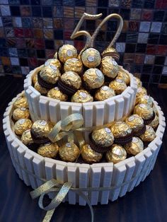 a cake made out of chocolates and wrapped in gold foil with a bow on top