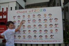 a young boy standing next to a sign that says class of 2012, st johns school