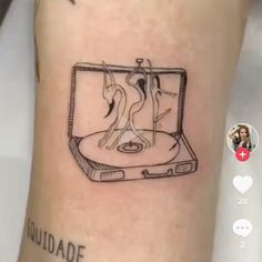 a tattoo on the leg of a person with a laptop in front of them and an image of two people