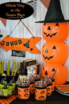 a halloween party with pumpkins and witches on the table in front of a sign that says witch way to the treats sign