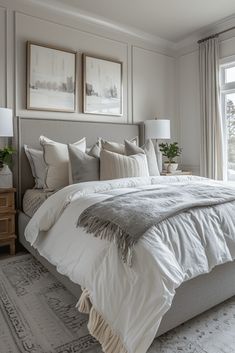 a large bed sitting in a bedroom next to a window with two pictures on the wall