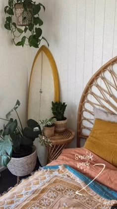 there is a bed with two plants on the wall and a surfboard in the corner