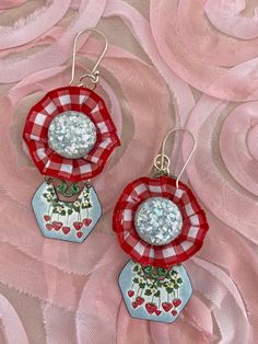 These earrings are chic and fun to wear.  So unique in design and components.  The top portion of these dangles have red and white small print ribbon encasing up-cycled vintage light blue cabs from a vintage set of earrings.  The cabs are so 50's with all the glitter type materials in them.  This is attached to a metal finding that has been painted a dark green.   The lower dangle portion are hand enameled metal with a strawberry motif.  If you follow me at all then you know I adore strawberry jewelry!   The 2 pieces together have great movement when worn and feel so stylish on.   The ear wires and jump rings are silver tone. These will arrive nicely packaged and ready for gift giving if desired.  Measurements: Length is 2-1/2" long, not including the ear wire portion.   Width is 1-1/2" at Playful Red Drop Earrings, Fun Red Round Jewelry, Playful Nickel-free Red Earrings, Playful Red Dangle Jewelry, Playful Red Nickel-free Jewelry, Red Enamel Earrings For Party, Playful Red Pierced Earrings, Playful Red Earrings For Pierced Ears, Whimsical Handmade Red Earrings