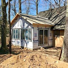 a house being built in the woods with siding on it's walls and windows