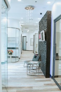 an empty hallway with chairs and tables in front of the glass doors that lead to another room