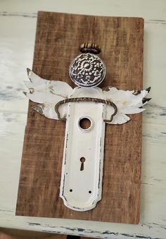 an old doorknob with a key on it is hanging from a wooden board