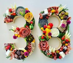 the number 30 made out of fruits and vegetables is displayed on a white surface with flowers