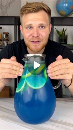 a man holding a blue vase with green liquid in it