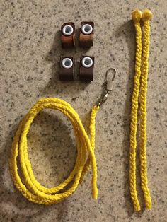 a yellow rope with two eyeballs on it next to some hooks and a pair of eyes