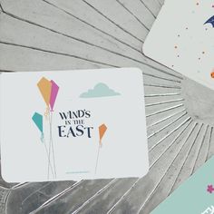 there are cards that say winds in the east and have colorful kites on them