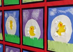 some paper cut out of eggs with ducks in them on a red wall and green grass