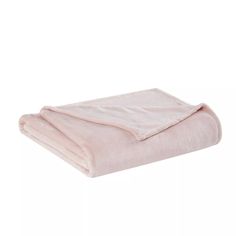 the pink blanket is folded up on top of a white background and it's light pink