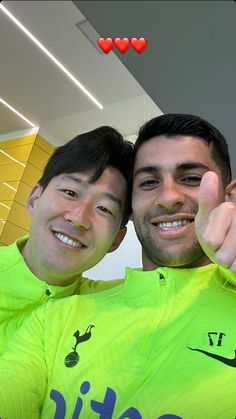 two men in yellow shirts giving the thumbs up