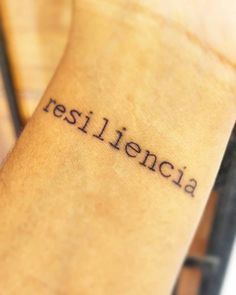 the word resilicia written in cursive ink on a woman's wrist