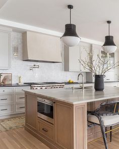 a kitchen with an island and two hanging lights