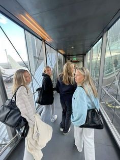 three women are walking up the glass walkway