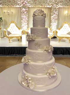 a three tiered wedding cake sitting on top of a table in front of a stage