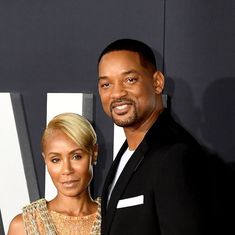 a man and woman standing next to each other on a red carpet