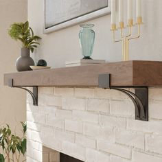 a white brick fireplace with candles and vases on it's mantel top