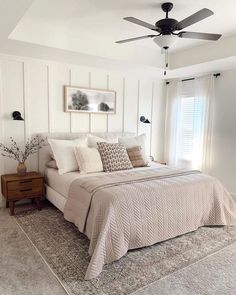 a bedroom with a bed, dresser and ceiling fan in it's centerpiece