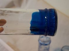 a hand holding a blue bottle with water in it