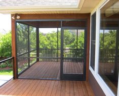 an enclosed porch with sliding glass doors and wood flooring on the side of it