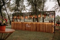 an outdoor bar with lights and flowers on it