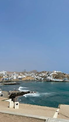 the beach is lined with houses and boats on it's shore, while blue skies are in the background