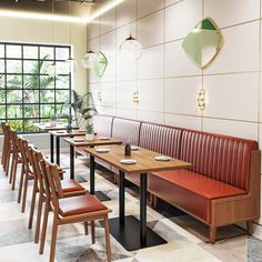 an empty restaurant with wooden benches and leather seats in front of a large window on the wall