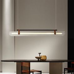 a dining room with a table and some lights hanging from it's ceiling fixture