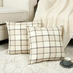 two pillows sitting on top of a white rug