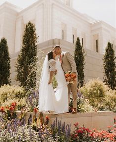 a bride and groom kissing in front of a building