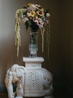 a vase with flowers and an elephant statue