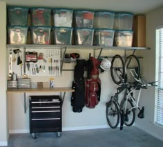 a garage with several storage bins on the wall and two bikes parked in front of it