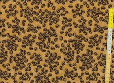 an animal print fabric with brown and black spots on the top, in front of a ruler