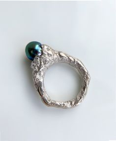 This Tahitian Black Pearl Mountain Ring is a nature-inspired piece of jewelry that resembles a majestic mountain. Its overall shape features an irregular texture, reminiscent of natural formations. Nestled in the center is a precious iridescent Tahitian pearl. This ring exudes a cool and gender-neutral style. This is a ready-to-ship item! -Gems Information Tahitian black pearl This pearl itself showcases a stunning color with high saturation and excellent luster. Its vibrant hue is a captivating blend of blue and green, while the ring's centerpiece emits a radiant halo of red light. -Size US 7, 25 can be sized, please contact me for more informations -Materials 925 silver -Packaging Your ring will arrive in a beautiful surprise gift box. Customization We offer the option to customize this Sea Inspired Jewellery, Irregular Rings, Sea Inspired Jewelry, Black Pearl Ring, Radiant Halo, Half Bezel Setting, Mountain Ring, Half Bezel, Sea Jewelry