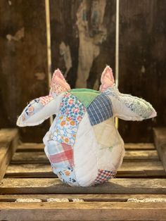 a stuffed animal sitting on top of a wooden crate